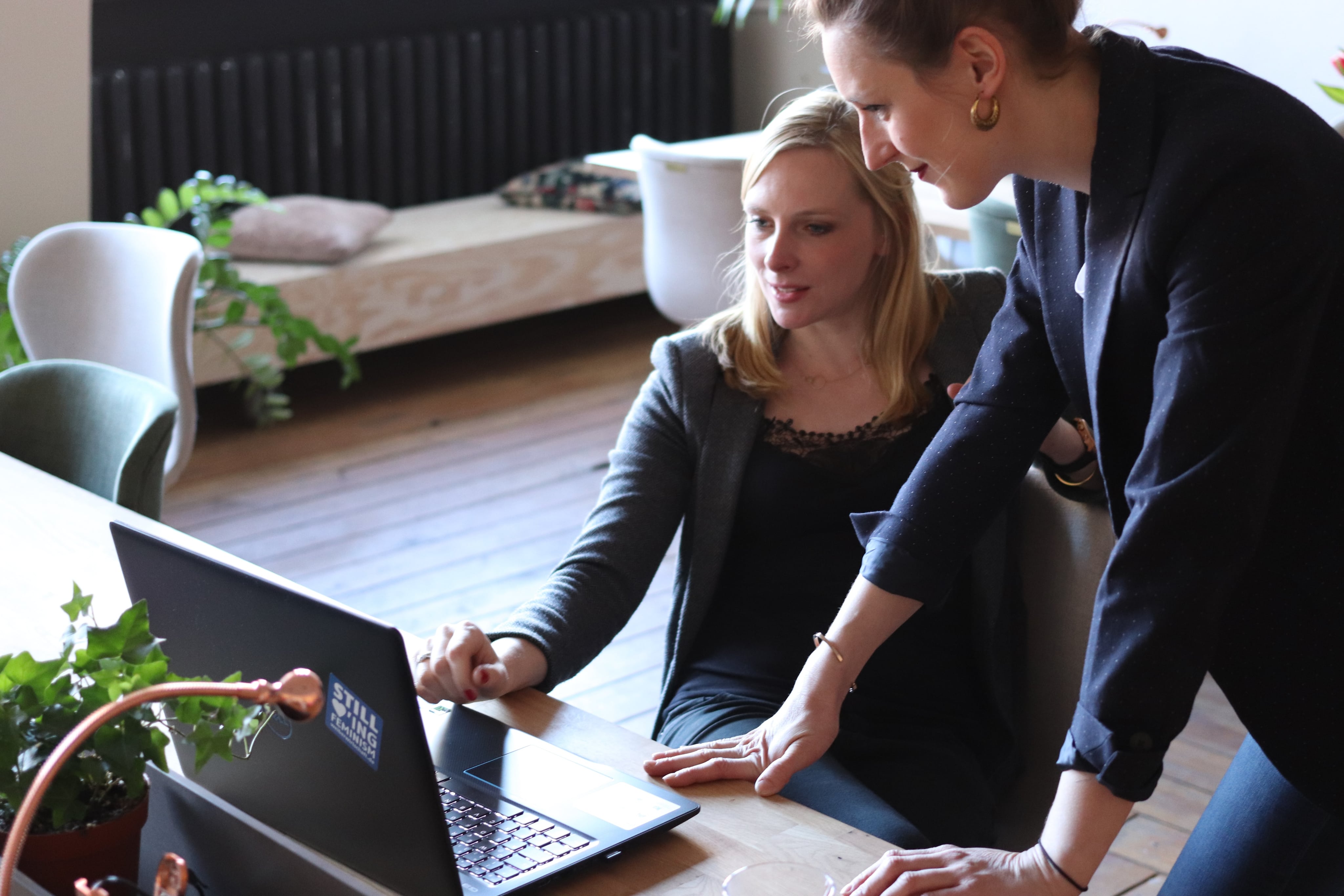 Two women staring at laptop